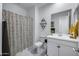 Bright bathroom features a shower with patterned curtain, and white vanity with a large mirror at 25658 N 140Th Ln, Surprise, AZ 85387