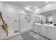 Bright bathroom featuring double vanities, a glass shower, and modern fixtures at 25658 N 140Th Ln, Surprise, AZ 85387
