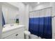 Bathroom with modern vanity, mirror, toilet, and shower with stylish blue and white curtain at 25658 N 140Th Ln, Surprise, AZ 85387