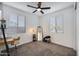 Bedroom with carpet flooring, two windows, and a ceiling fan at 25658 N 140Th Ln, Surprise, AZ 85387