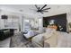 Bright living room with a large sectional sofa, stylish decor, and a modern ceiling fan at 25658 N 140Th Ln, Surprise, AZ 85387