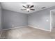 Spacious bedroom features gray walls, carpet flooring, a ceiling fan, and a window at 25723 S Hawes Rd, Queen Creek, AZ 85142