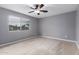 This bedroom features gray walls, carpet flooring, a window, and a ceiling fan at 25723 S Hawes Rd, Queen Creek, AZ 85142