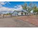 Charming gray single story home with stone accents, mature trees, and gravel driveway at 25723 S Hawes Rd, Queen Creek, AZ 85142