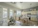 Sunlit kitchen showcasing white cabinets, an island with seating, and outdoor access with view of backyard at 2621 S 157Th Dr, Goodyear, AZ 85338