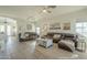 Spacious living room with neutral color palette, ceiling fans, tile floors, and comfortable leather furniture at 2621 S 157Th Dr, Goodyear, AZ 85338