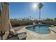 A beautiful backyard with a large sparkling pool and lounge chairs, surrounded by palm trees at 2621 S 157Th Dr, Goodyear, AZ 85338