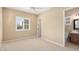 Bright bedroom with neutral carpet, ceiling fan, and natural light coming through the window with shutters at 26616 W Quail Ave, Buckeye, AZ 85396