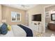 Cozy bedroom featuring natural light from a large window, ceiling fan, and en-suite bathroom access at 26616 W Quail Ave, Buckeye, AZ 85396