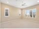 Neutral-toned bedroom with a ceiling fan and plenty of natural light from the shuttered windows at 26616 W Quail Ave, Buckeye, AZ 85396