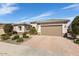 Attractive single-story home with well-kept desert landscaping, a brick-paved driveway, and a convenient two-car garage at 26616 W Quail Ave, Buckeye, AZ 85396