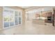 Bright and airy living room with tile flooring, access to kitchen, and sliding glass doors leading to the backyard at 26616 W Quail Ave, Buckeye, AZ 85396