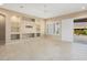 Bright living room with built-in shelving, tile flooring, and large sliding glass doors for indoor-outdoor living at 26616 W Quail Ave, Buckeye, AZ 85396
