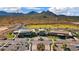 An aerial view of the community clubhouse, golf course, parking lot, and desert mountains in the background at 26828 W Piute Ave, Buckeye, AZ 85396