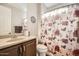 Bathroom featuring a single vanity with a granite countertop, toilet, and shower with patterned curtain at 26828 W Piute Ave, Buckeye, AZ 85396