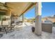 Inviting covered patio with stone pavers, ceiling fans, and outdoor seating area perfect for entertaining guests at 26828 W Piute Ave, Buckeye, AZ 85396