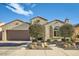 Inviting single-story stucco home with a two-car garage, desert landscaping, and a brick-paved driveway at 26828 W Piute Ave, Buckeye, AZ 85396