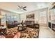 Comfortable living room featuring neutral tones, plush seating, a ceiling fan, and large windows at 26828 W Piute Ave, Buckeye, AZ 85396