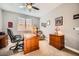 Cozy home office with wood furniture, comfortable chair, and natural light from the window at 26828 W Piute Ave, Buckeye, AZ 85396