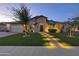 Charming home featuring a manicured lawn, desert landscaping and illuminated walkway at 2882 E Wildhorse E Dr, Gilbert, AZ 85297