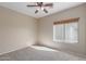 Neutral bedroom features a ceiling fan, carpet flooring, and a window to let natural light in at 28933 N Saddle Way, San Tan Valley, AZ 85143