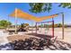 Community playground with swings, slide, climbing structure and shade canopy at 28933 N Saddle Way, San Tan Valley, AZ 85143