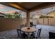 Cozy covered patio with a dining table, string lights, and a brick fence at 3010 W Laredo Ln, Phoenix, AZ 85085