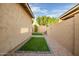 Narrow backyard featuring artificial turf, a gravel area, and a tan privacy wall at 3010 W Laredo Ln, Phoenix, AZ 85085