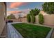 Beautiful backyard with a lush lawn, string lights, a brick surround and privacy wall at 3010 W Laredo Ln, Phoenix, AZ 85085