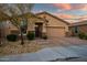 Charming home exterior with a two-car garage, stone accents, and a well-manicured front yard at 3010 W Laredo Ln, Phoenix, AZ 85085