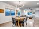 Open living area with dining table and chairs, modern lighting, and windows at 3010 W Laredo Ln, Phoenix, AZ 85085