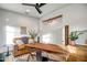 Bright room with white walls, modern chair, leather sofa, and a dark ceiling fan at 3010 W Laredo Ln, Phoenix, AZ 85085