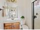 Bright bathroom boasts a vanity with wooden cabinets, large mirror, and step-in shower at 31106 N 138Th Ave, Peoria, AZ 85383