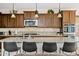 Gourmet kitchen with stainless appliances, dark wood cabinets, granite counters, and island seating at 31106 N 138Th Ave, Peoria, AZ 85383