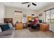 Inviting office space with natural light, a ceiling fan, a gray sofa and wood cabinets and desk at 31106 N 138Th Ave, Peoria, AZ 85383
