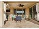 Cozy covered patio is furnished with comfortable seating, an outdoor fan, and sliding glass doors at 31106 N 138Th Ave, Peoria, AZ 85383
