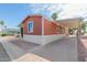 Wide shot of a quaint home with a large covered carport and mature landscaping at 320 E Mckellips Rd # 166, Mesa, AZ 85201