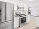 Modern kitchen with stainless steel appliances, white cabinets and granite countertops at 3227 E Enid Ave, Mesa, AZ 85204