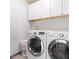 Functional laundry room with overhead cabinets and side-by-side washer and dryer at 3227 E Enid Ave, Mesa, AZ 85204