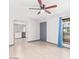Bright living room featuring wood floors, ceiling fan, and view into a well lit modern kitchen at 3227 E Enid Ave, Mesa, AZ 85204
