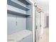 Mudroom with bench seating, coat hooks, shelves, and a sliding barn door at 3227 E Enid Ave, Mesa, AZ 85204