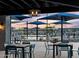 Poolside seating area with tables and chairs under umbrellas with playground in the background at 3598 E Alexander Dr, San Tan Valley, AZ 85143