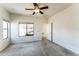 Bright, spacious bedroom with carpet, ceiling fan, and natural light from a large window at 44922 W Alamendras St, Maricopa, AZ 85139