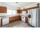 Well-equipped kitchen featuring stainless steel refrigerator and plentiful wood cabinet space at 44922 W Alamendras St, Maricopa, AZ 85139