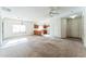 Open-concept living room with neutral carpet, connecting to the kitchen area, providing ample space at 44922 W Alamendras St, Maricopa, AZ 85139