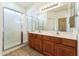 Bathroom featuring a glass-enclosed shower and double sink vanity at 44922 W Alamendras St, Maricopa, AZ 85139