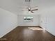 Living room featuring a ceiling fan, a window for natural light, and a door to another room at 4644 E Southern Ave, Phoenix, AZ 85042