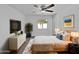 Cozy main bedroom featuring neutral tones, soft carpet, a ceiling fan, and a large window at 4644 E Southern Ave, Phoenix, AZ 85042