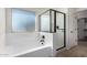 Bathroom features a shower and bathtub combination, tile flooring, and a privacy window at 4744 E Tierra Buena Ln, Phoenix, AZ 85032