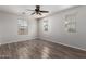 Bright bedroom featuring a ceiling fan, wood-look flooring, and natural light from three windows at 4744 E Tierra Buena Ln, Phoenix, AZ 85032
